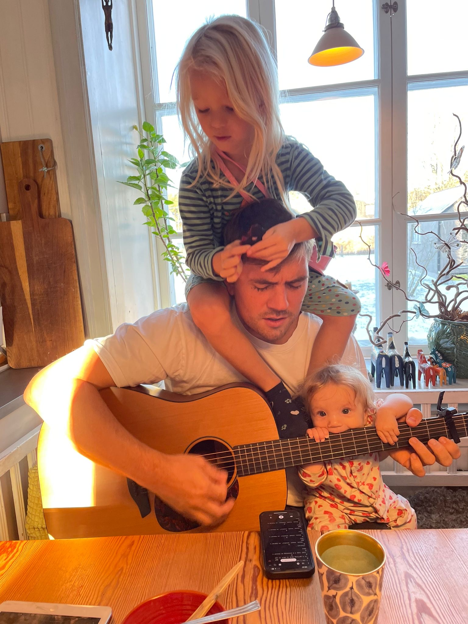 Henrik spelar gitarr med barnen